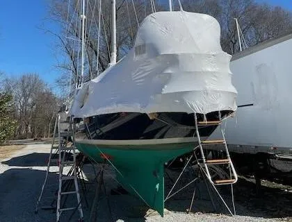 Slide: The Image of 1981 Bristol 40 Sloop sailboat covered in protective wrap, on land with ladders nearby. - 35