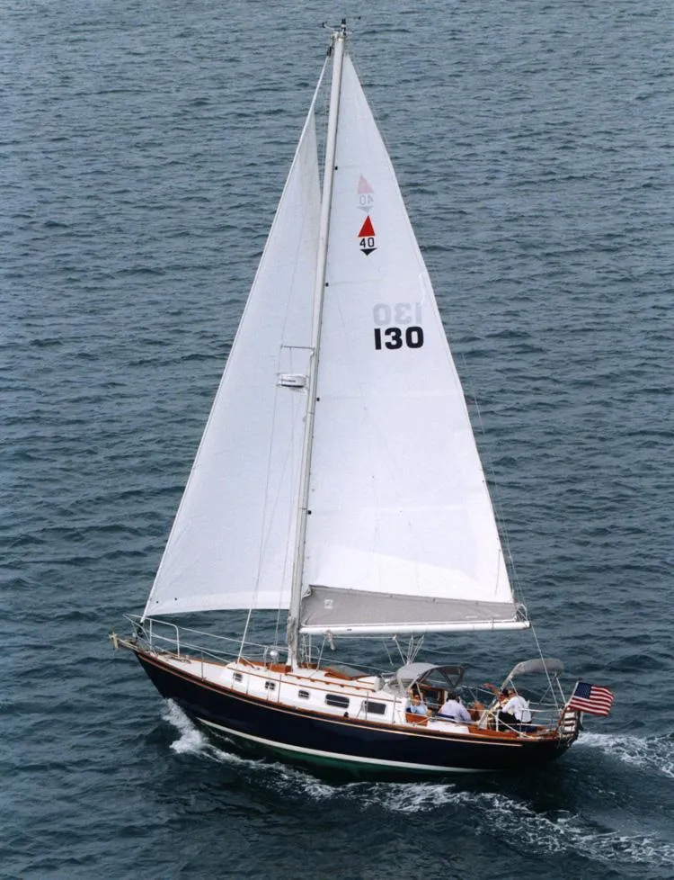 Slide: The Image of 1981 Bristol 40 sloop sailing on open water, white sails, American flag. - 38