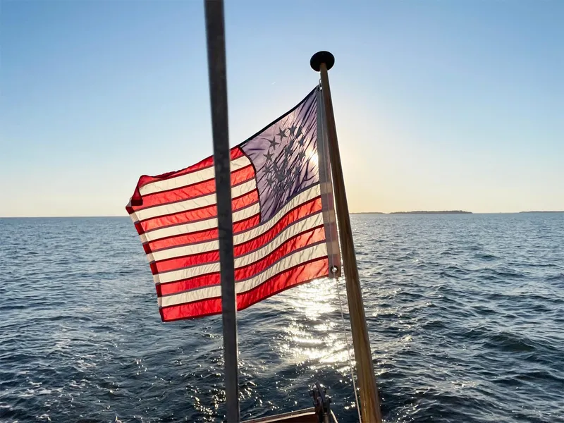 Slide: The Image of American flag on a 1981 Bristol 40 sloop, sailing on a sunny day. - 42