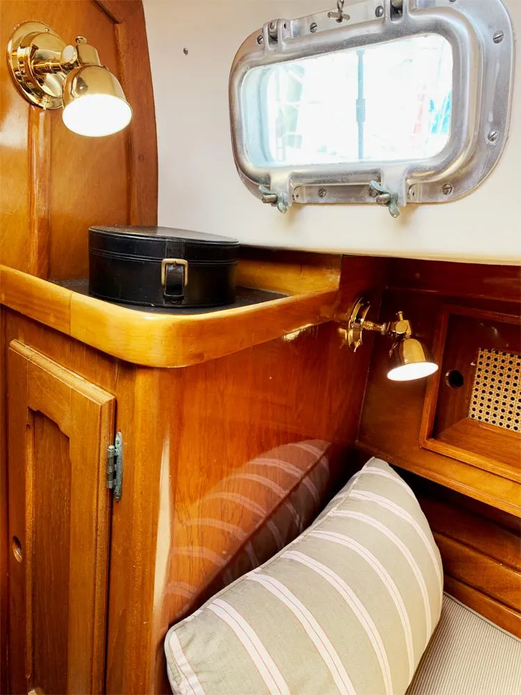 Slide: The Image of Interior of 1981 Bristol 40 Sloop with wooden cabinetry and striped cushion. - 7