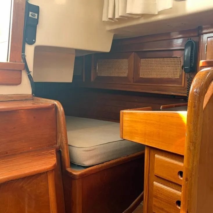 Slide: The Image of Interior of 1981 Bristol 40 Sloop, featuring wooden cabinetry and a cozy sleeping area. - 8