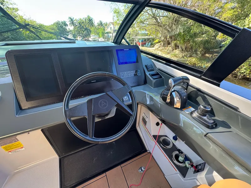 Slide: The Image of 2022 Aviara AV36 OB boat cockpit with steering wheel, controls, and navigation display. - 16