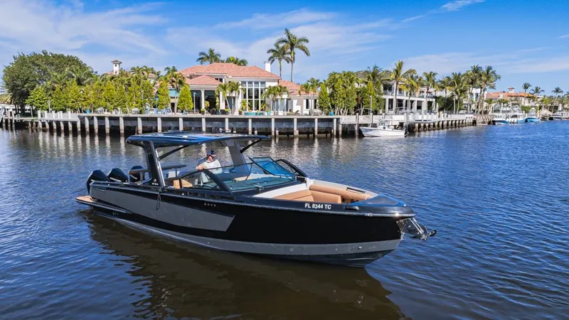 Slide: The Image of 2022 Aviara AV36 OB boat cruising on a scenic waterfront with luxury homes. - 6