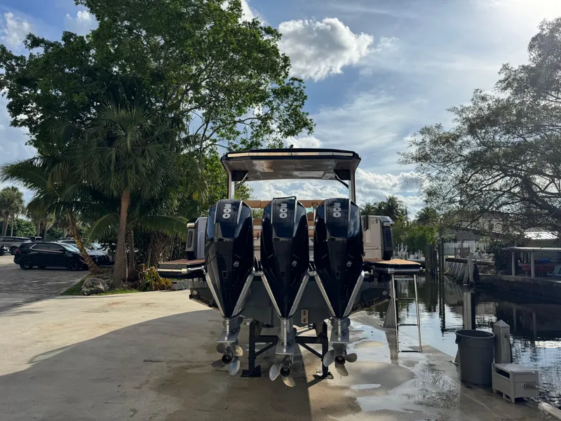 Slide: The Image of 2022 Aviara AV36 OB boat with triple outboard engines docked by a scenic waterfront. - 9