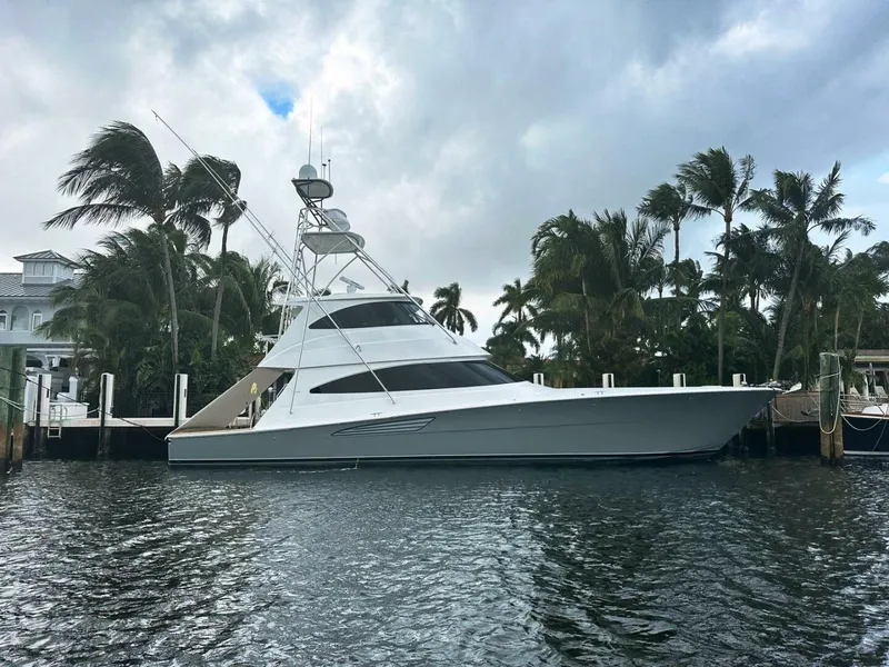 Slide: The Image of 2024 Viking 68 Enclosed Bridge yacht docked by palm trees. - 1