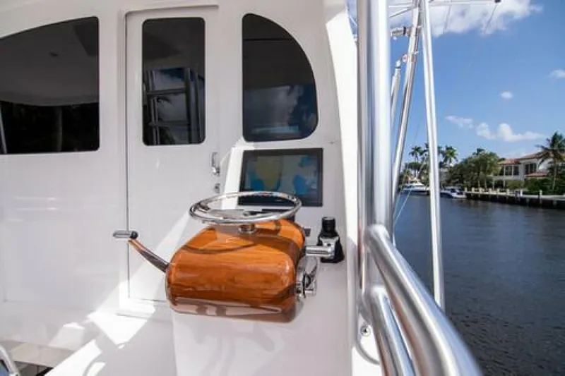 Slide: The Image of 2024 Viking 68 Enclosed Bridge yacht helm with wooden controls, dockside view. - 14