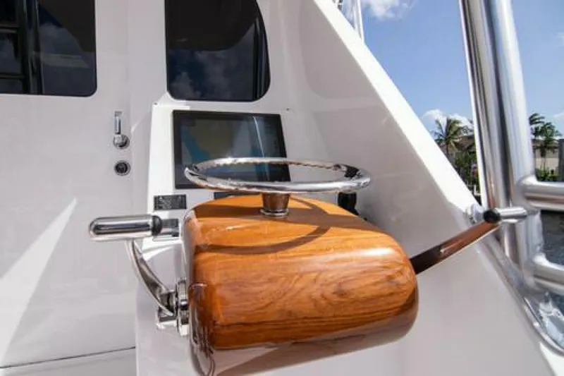 Slide: The Image of 2024 Viking 68 Enclosed Bridge helm with wooden steering wheel and control panel. - 16