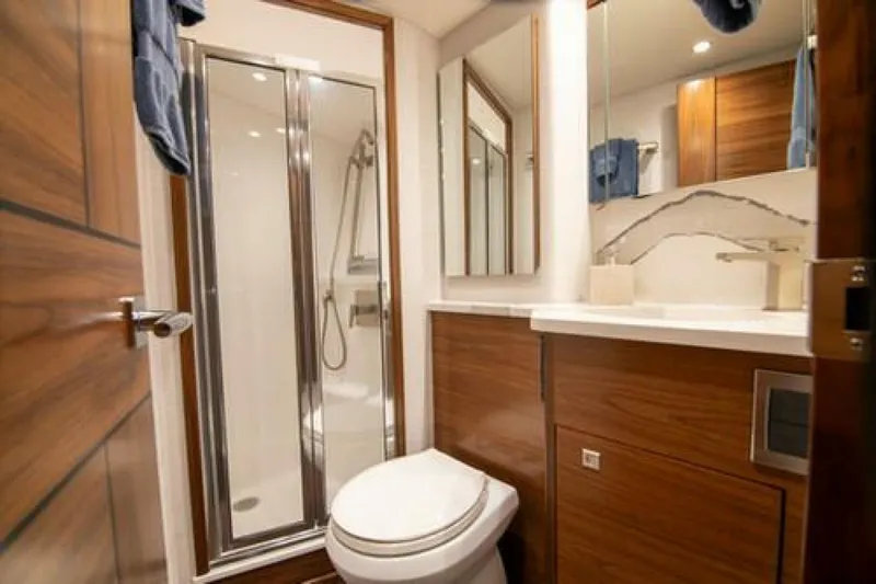 Slide: The Image of Luxurious bathroom in 2024 Viking 68 Enclosed Bridge yacht with modern fixtures and wood accents. - 23