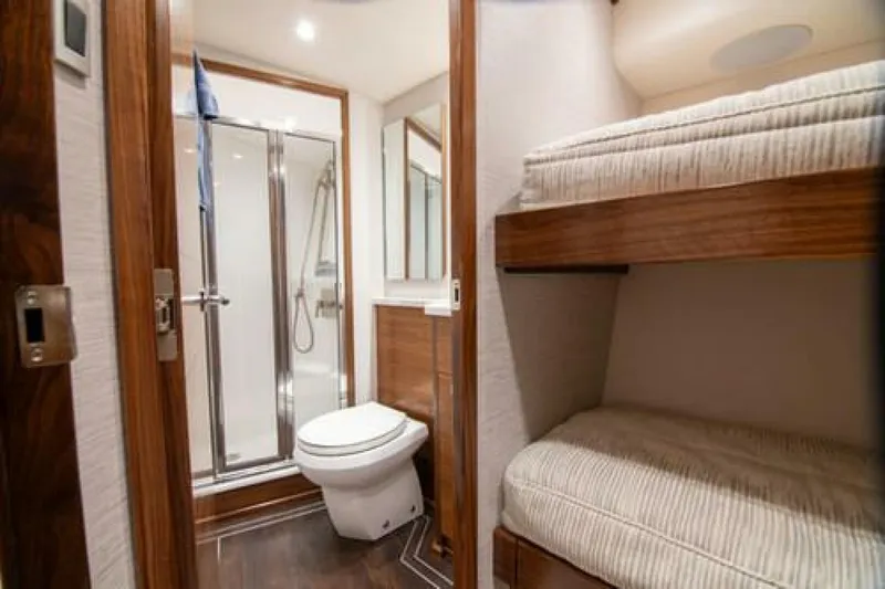 Slide: The Image of 2024 Viking 68 Enclosed Bridge yacht interior with bathroom and bunk beds. - 24
