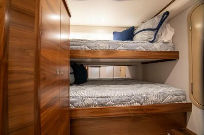 Slide: The Image of Bunk beds in 2024 Viking 68 Enclosed Bridge yacht cabin with wooden finishes. - 26