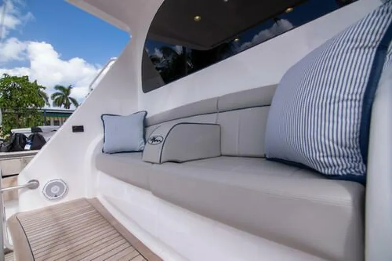 Slide: The Image of 2024 Viking 68 Enclosed Bridge yacht with cushioned seating and decorative pillows. - 31