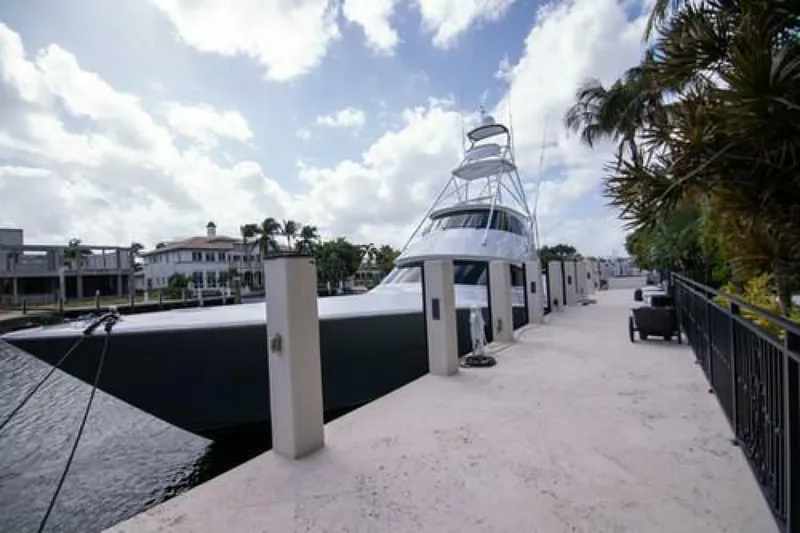 Slide: The Image of 2024 Viking 68 Enclosed Bridge yacht docked by a waterfront walkway. - 35