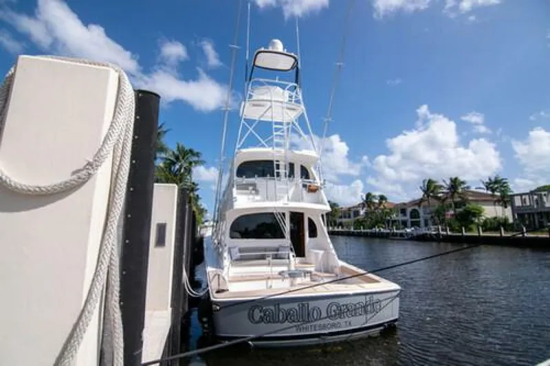 Slide: The Image of 2024 Viking 68 Enclosed Bridge yacht docked by a scenic waterfront. - 38
