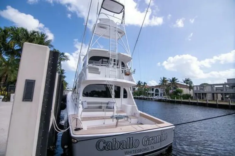 Slide: The Image of 2024 Viking 68 Enclosed Bridge yacht docked by waterfront homes. - 39