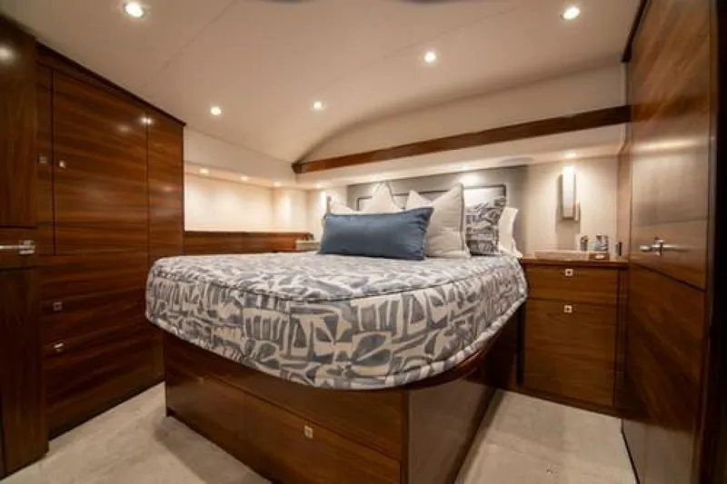 Slide: The Image of Luxurious bedroom interior of 2024 Viking 68 Enclosed Bridge yacht with elegant wood finishes. - 4