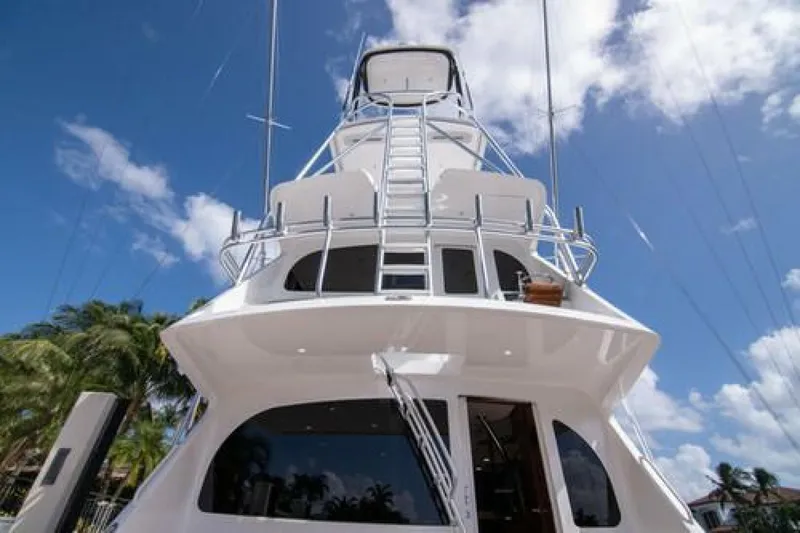 Slide: The Image of 2024 Viking 68 Enclosed Bridge yacht against a clear blue sky. - 40