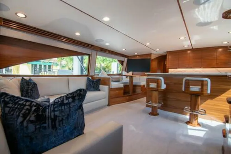 Slide: The Image of Luxurious interior of 2024 Viking 68 Enclosed Bridge yacht with elegant seating and wood finishes. - 7