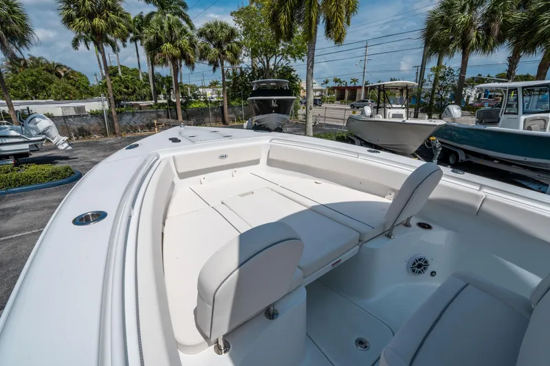 Slide: The Image of 2025 Sea Hunt Gamefish 25 boat interior with seating, parked outdoors under palm trees. - 26