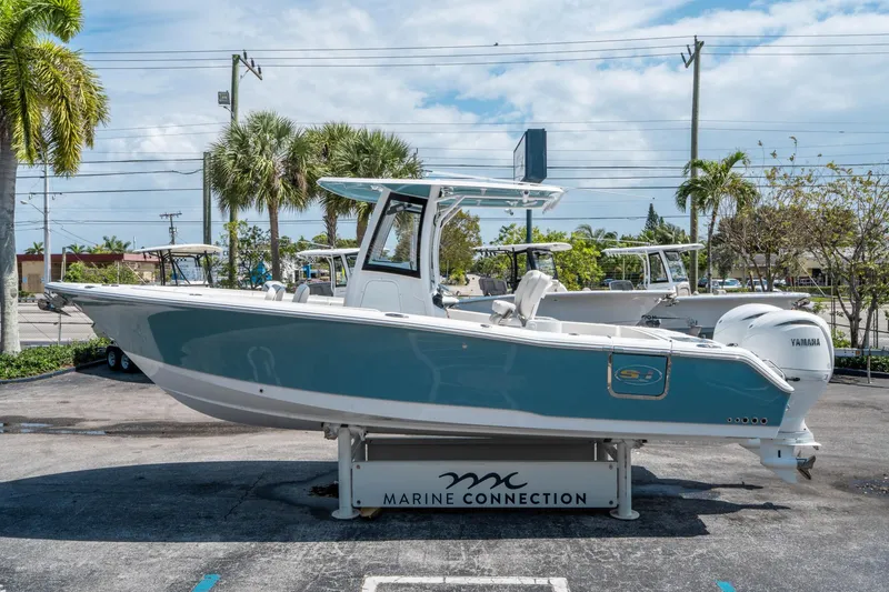 Slide: The Image of 2025 Sea Hunt Gamefish 25 boat displayed outdoors at Marine Connection dealership. - 5