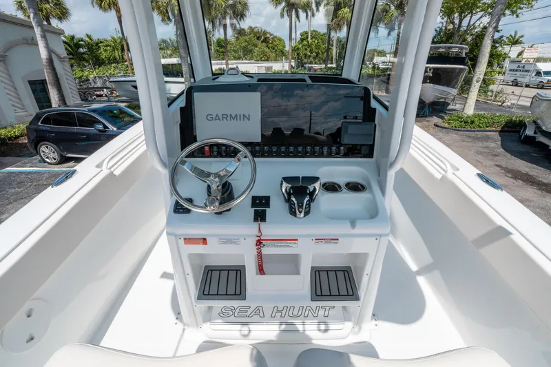 Slide: The Image of 2025 Sea Hunt Gamefish 25 boat dashboard with Garmin navigation system and steering wheel. - 19
