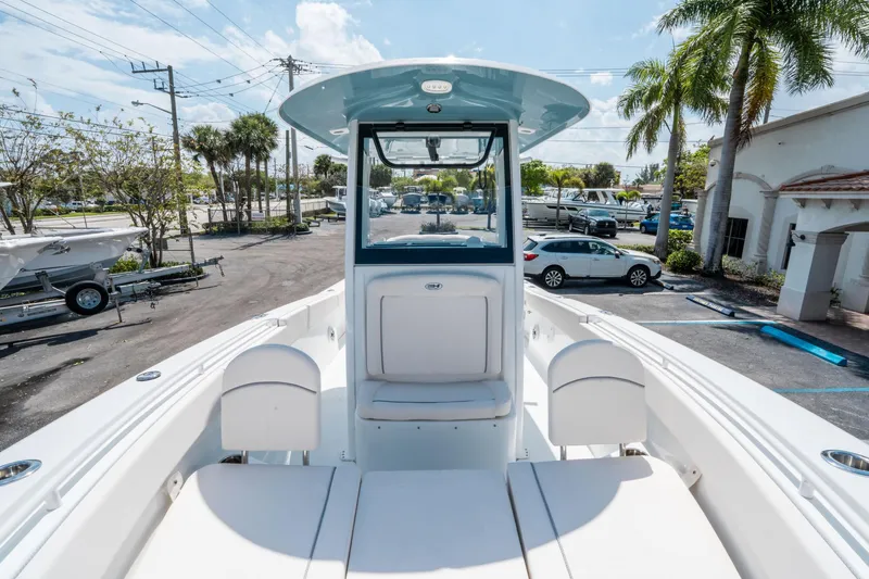 Slide: The Image of 2025 Sea Hunt Gamefish 25 boat interior with seating, parked outdoors under clear sky. - 27