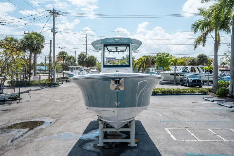 Slide: The Image of 2025 Sea Hunt Gamefish 25 boat displayed in a sunny parking lot. - 7