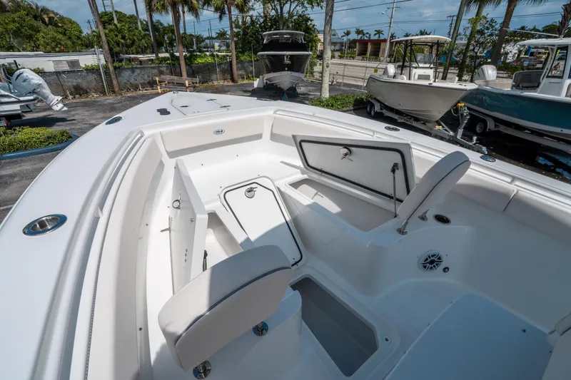 Slide: The Image of 2025 Sea Hunt Gamefish 25 boat interior with open storage compartments, parked outdoors. - 29