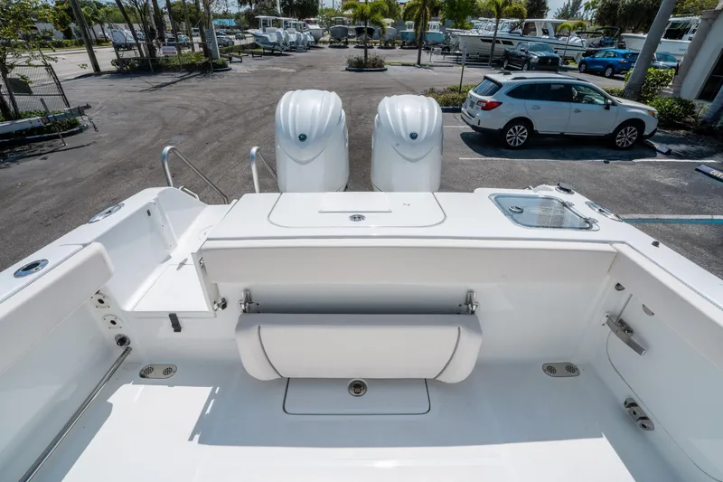 Slide: The Image of 2025 Sea Hunt Gamefish 25 boat with dual engines in a parking lot. - 10
