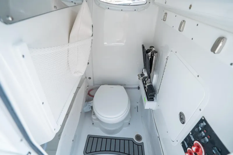 Slide: The Image of Interior of 2025 Sea Hunt Gamefish 25 boat, featuring a compact marine toilet. - 25