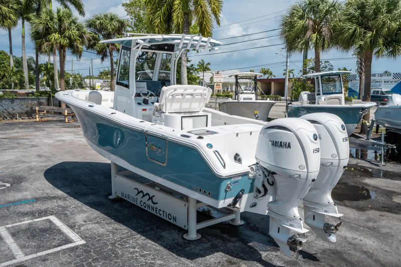 Slide: The Image of 2025 Sea Hunt Gamefish 25 boat with twin Yamaha engines, parked outdoors. - 4