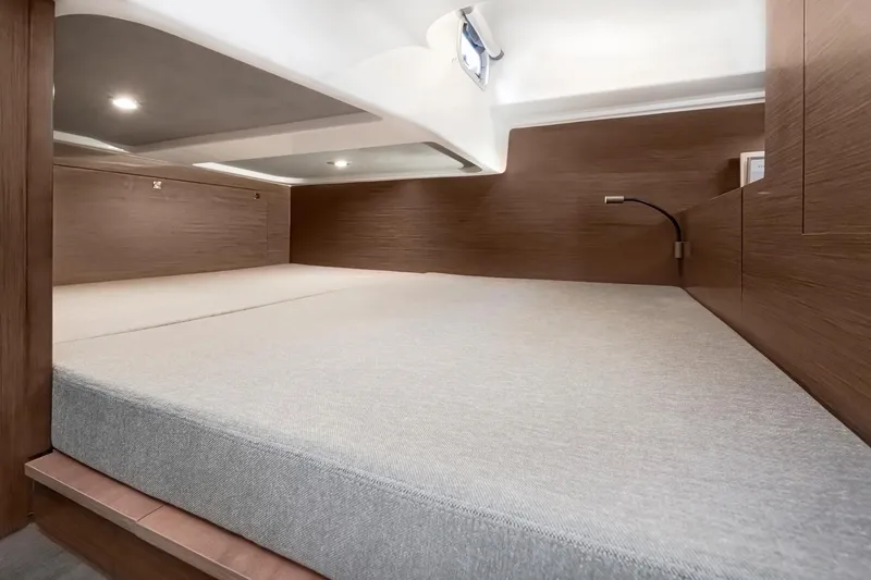 Slide: The Image of 2025 Beneteau 32 Gran Turismo cabin interior with modern wood finish and spacious bed. - 20