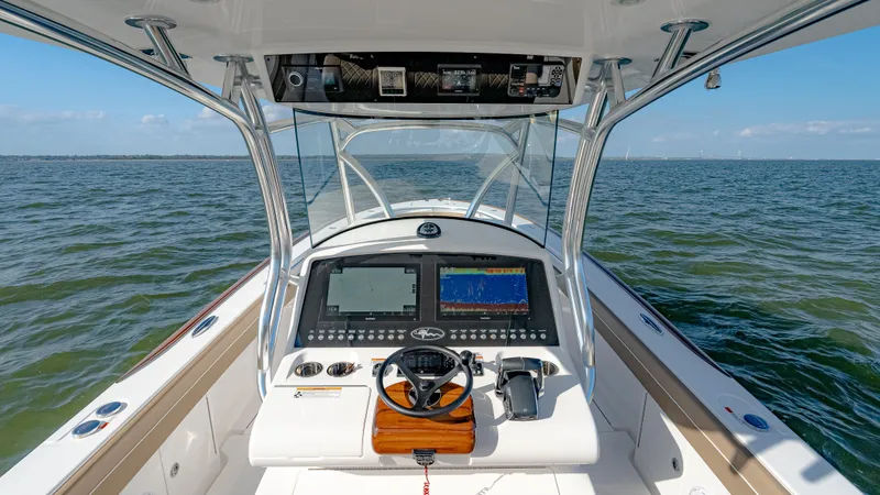 Slide: The Image of 2025 Valhalla Boatworks V-33 helm with advanced navigation systems on open water. - 28