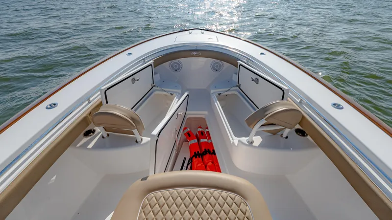 Slide: The Image of 2025 Valhalla Boatworks V-33 interior, featuring seating and storage, on calm water. - 34