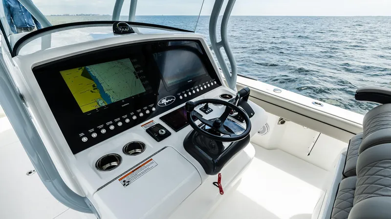 Slide: The Image of 2025 Valhalla Boatworks V-33 helm with advanced navigation system on open water. - 16
