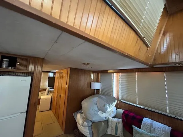 Slide: The Image of Interior of a 1995 Gibson 5500 Series boat with wood paneling and cozy furnishings. - 2