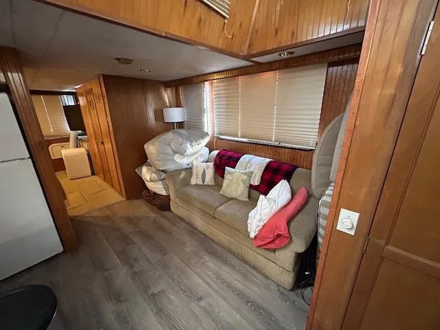 Slide: The Image of Cozy interior of a 1995 Gibson 5500 SERIES houseboat with wood paneling and comfortable seating. - 21