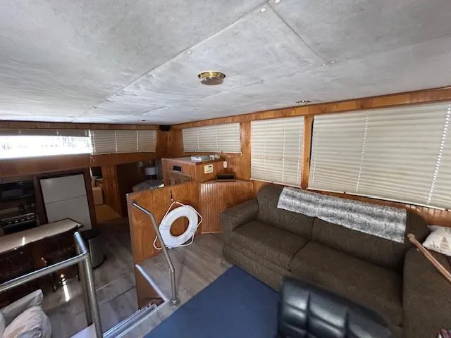 Slide: The Image of Interior of a 1995 Gibson 5500 SERIES houseboat with cozy seating and wood paneling. - 24