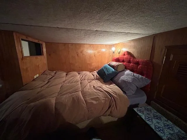 Slide: The Image of Cozy bedroom with wood paneling, red tufted headboard, and soft lighting in a 1995 Gibson 5500 Series. - 26