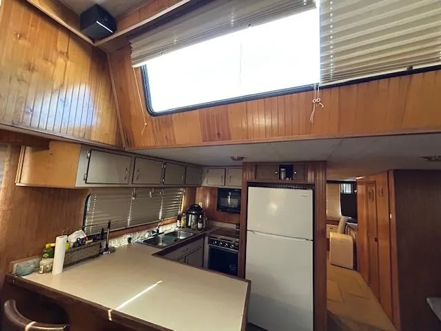 Slide: The Image of 1995 Gibson 5500 SERIES boat kitchen with wood paneling, skylight, and modern appliances. - 3