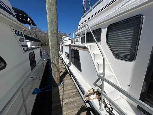 Slide: The Image of 1995 Gibson 5500 SERIES boat docked, showing side view with stairs and railing. - 32