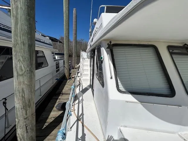 Slide: The Image of 1995 Gibson 5500 SERIES boat docked, side view with clear blue sky. - 33