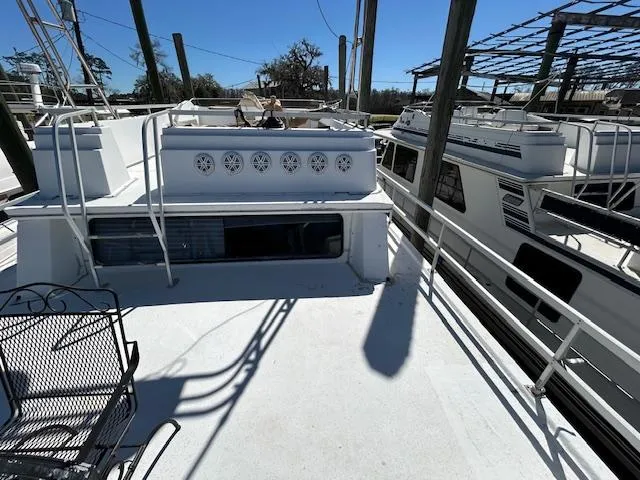 Slide: The Image of 1995 Gibson 5500 SERIES boat deck with railing and seating, docked alongside other boats. - 44