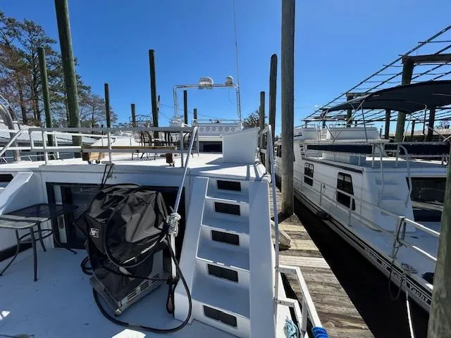 Slide: The Image of Gibson 5500 SERIES houseboat docked, featuring upper deck and clear blue sky, 1995 model. - 48