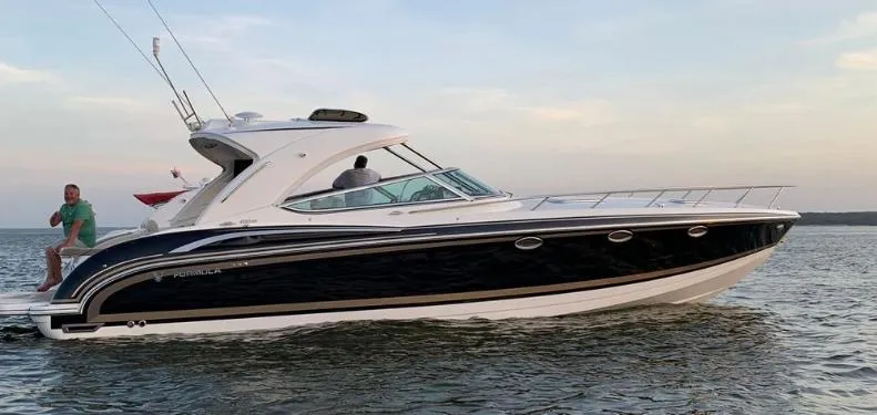 Slide: The Image of 2016 Formula 400 Super Sport boat cruising on calm water at sunset. - 2