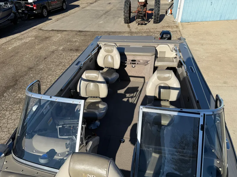 Slide: The Image of 2001 Lund 1950 Tyee Magnum GS ITS boat with beige seating, parked outdoors. - 17
