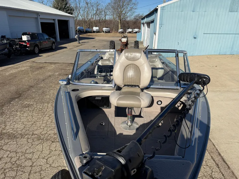 Slide: The Image of 2001 Lund 1950 Tyee Magnum GS ITS boat with seating and steering wheel, parked outdoors. - 9