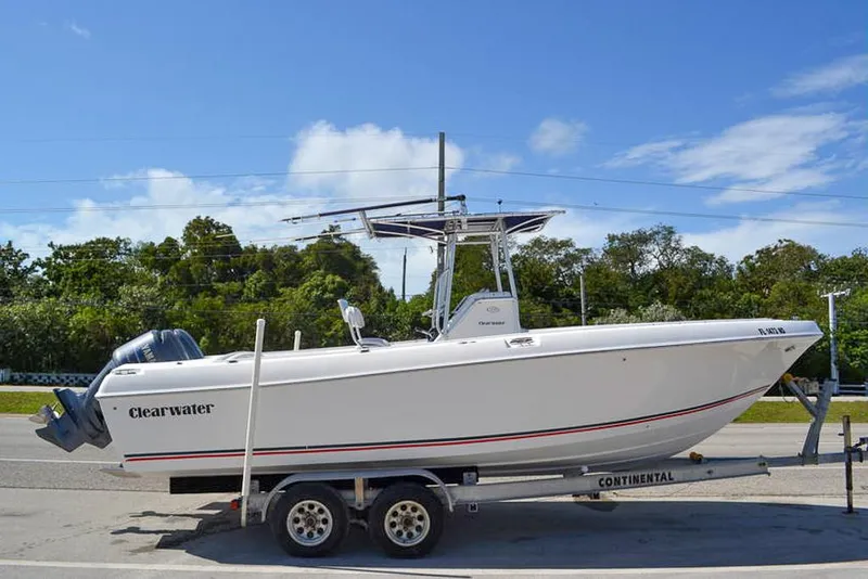 Slide: The Image of 2006 Clearwater 2500 WI CC boat on trailer, parked outdoors under blue sky. - 1