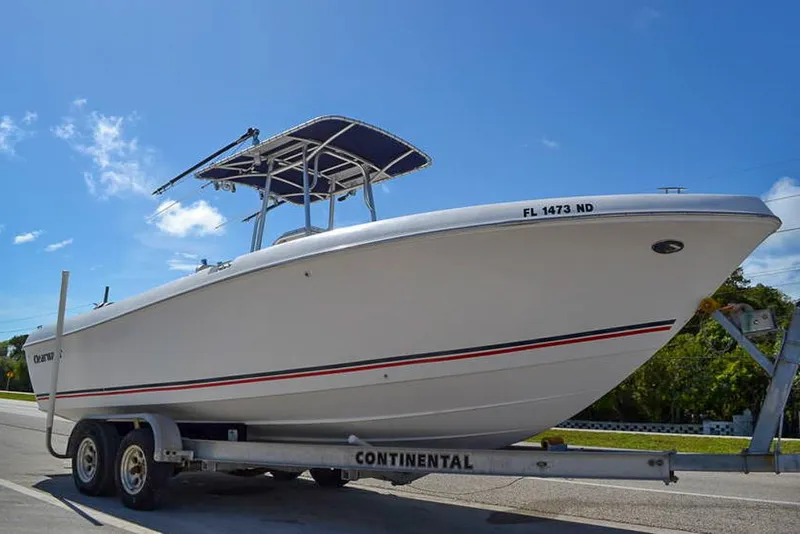 Slide: The Image of 2006 Clearwater 2500 WI CC boat on trailer, parked outdoors under blue sky. - 2