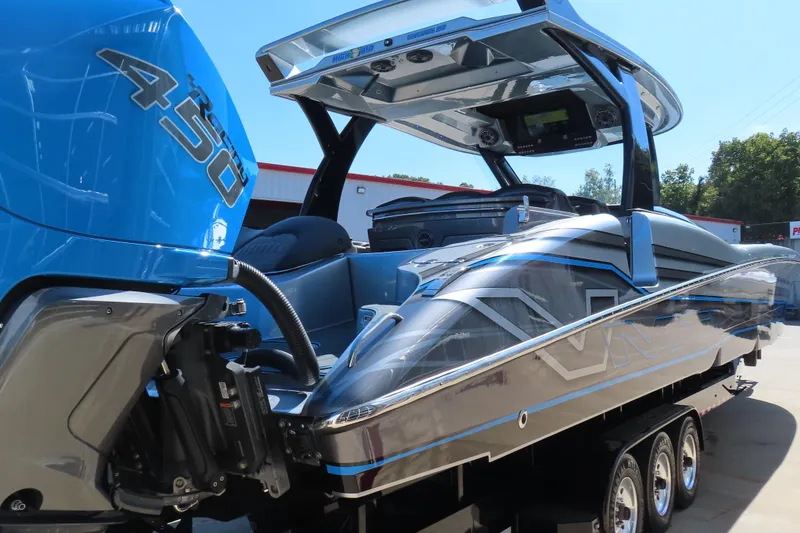 Slide: The Image of 2022 MTI 50v powerboat with blue Mercury 450R engine, sleek design, and triple-axle trailer. - 37