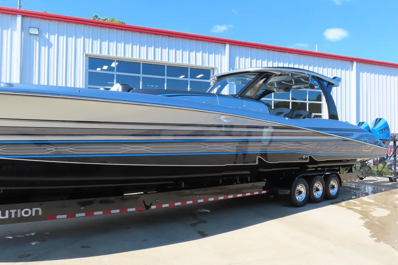 Slide: The Image of 2022 MTI 50v boat on trailer outside a building under clear blue sky. - 43